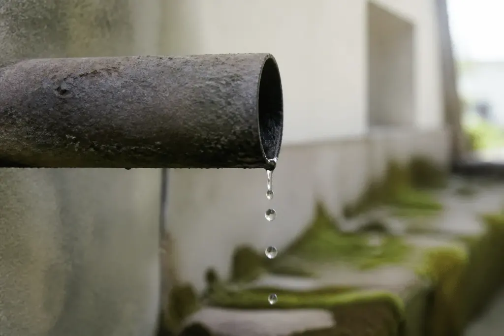 Gouttes d'eau s'echappant d'un tuyau metallique rouille