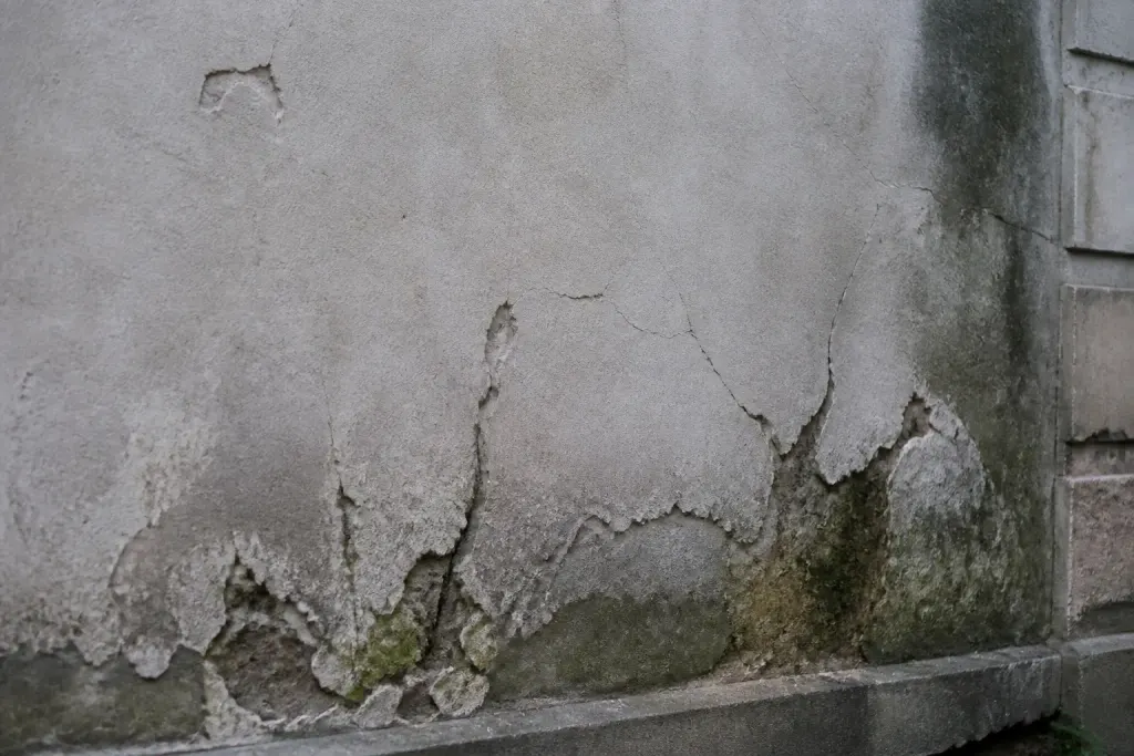 Mur presentant fissures zones creuses et humidite