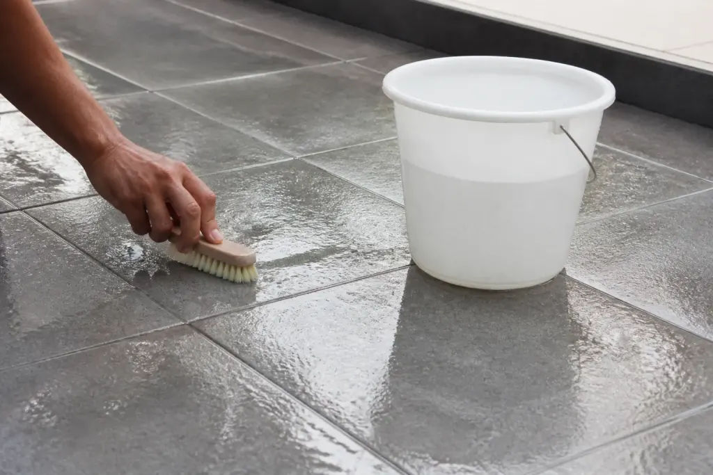 Carrelage gris humide brosse douce seau plastique blanc