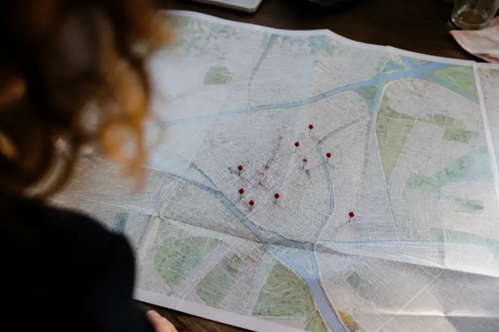 Carte papier du quartier avec epingles rouges sur table