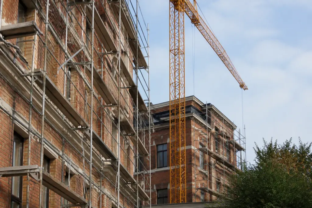 Immeubles en briques en travaux avec echafaudage et grue