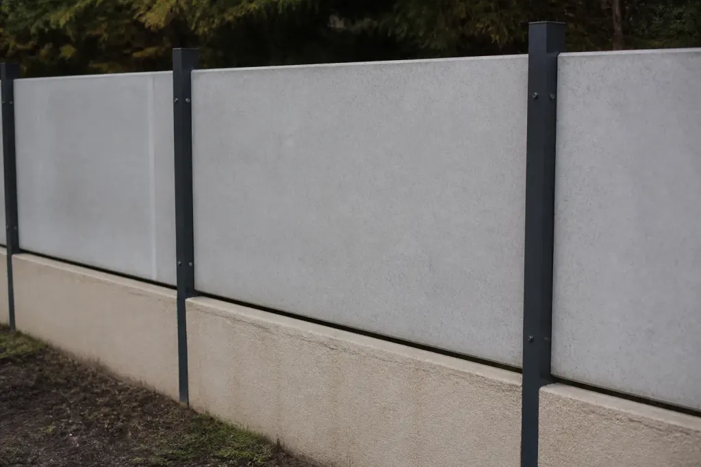 Plaques de beton posees entre poteaux metalliques sur muret