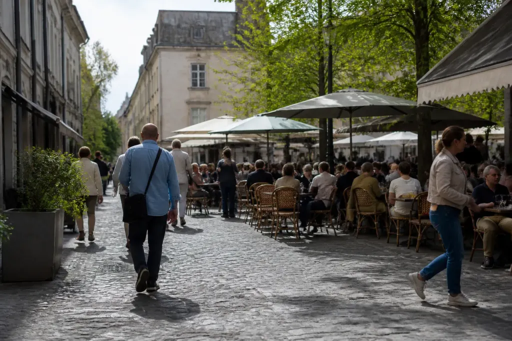 Rue pavee animee avec terrasses de cafes au centre