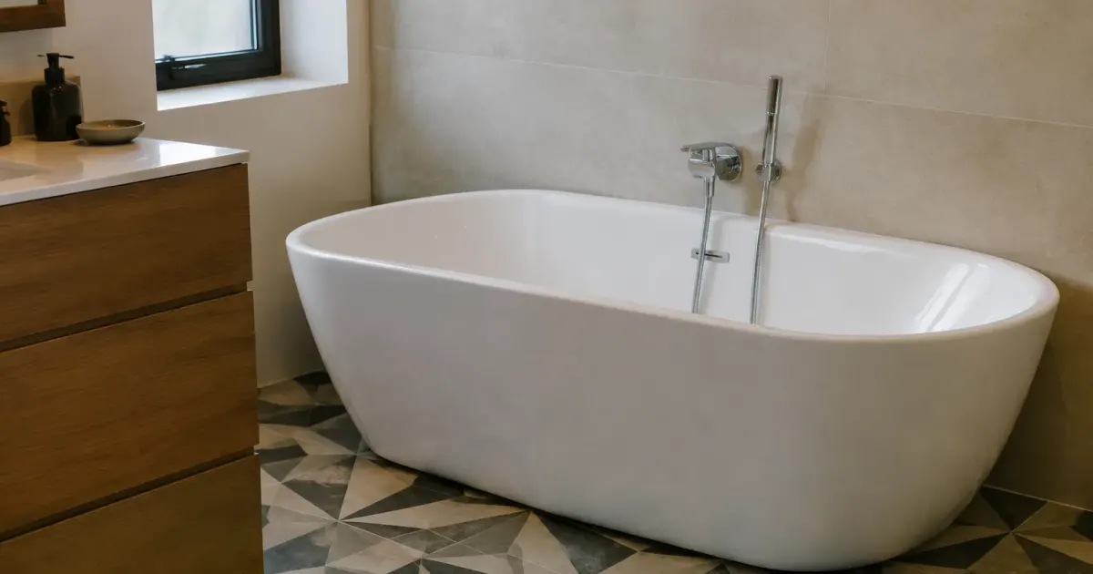 Sol à motifs géométriques, baignoire blanche contre mur