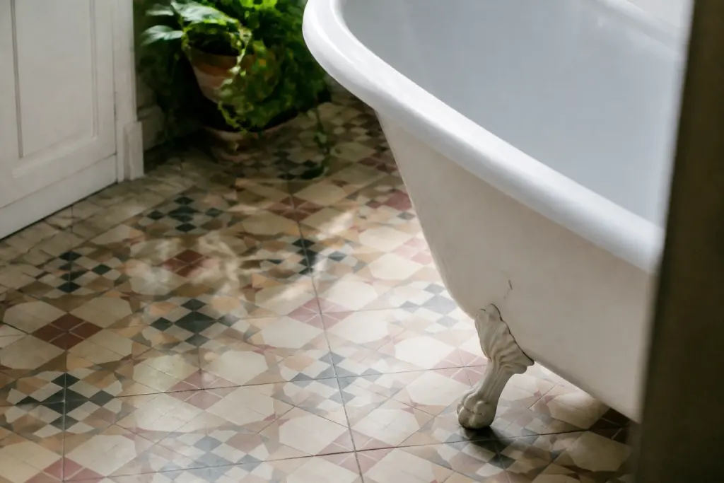 Sol aux motifs geometriques colores et baignoire blanche ancienne